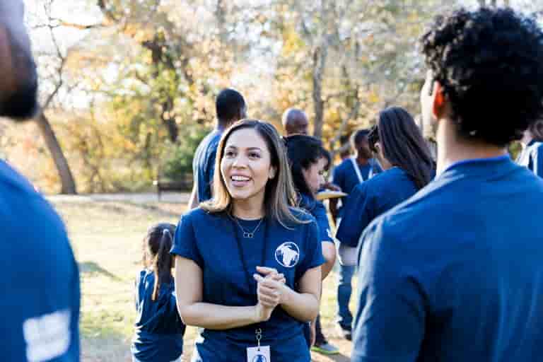Smiling volunteer in blue shirt at park