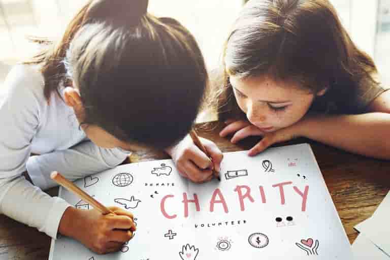 Two children creating charity poster together