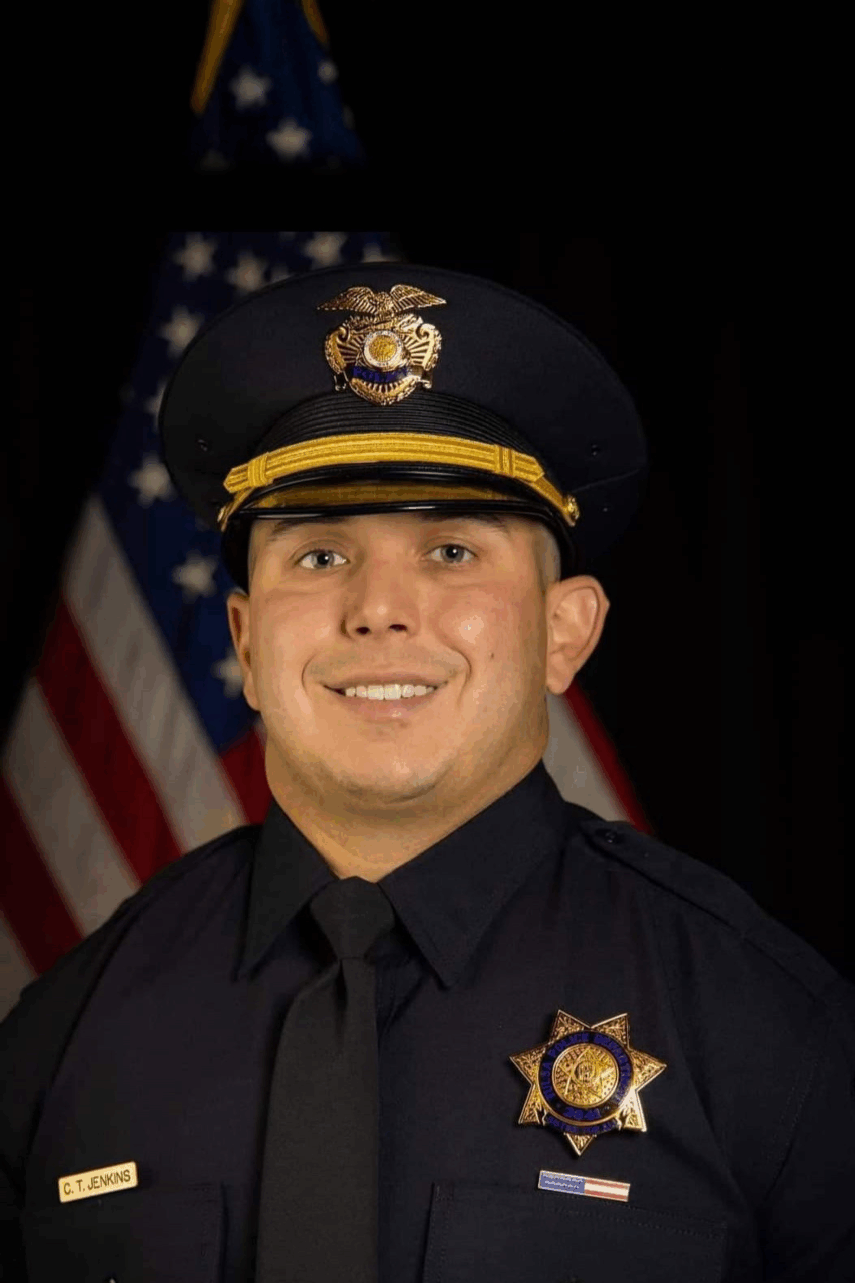 Smiling uniformed police officer with American flag